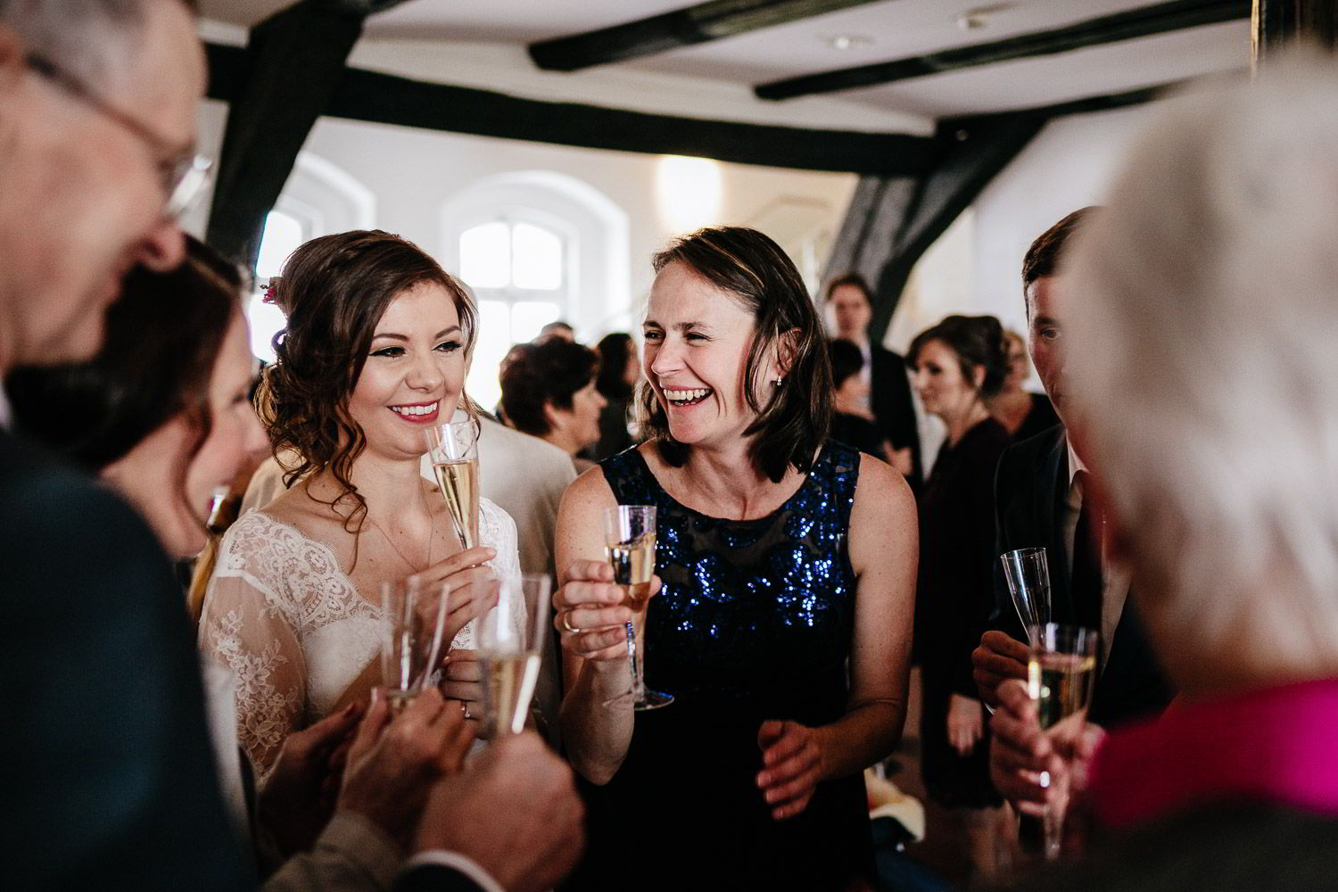 Hochzeitsgäste lachen mit Braut im Residenzmuseum Celle