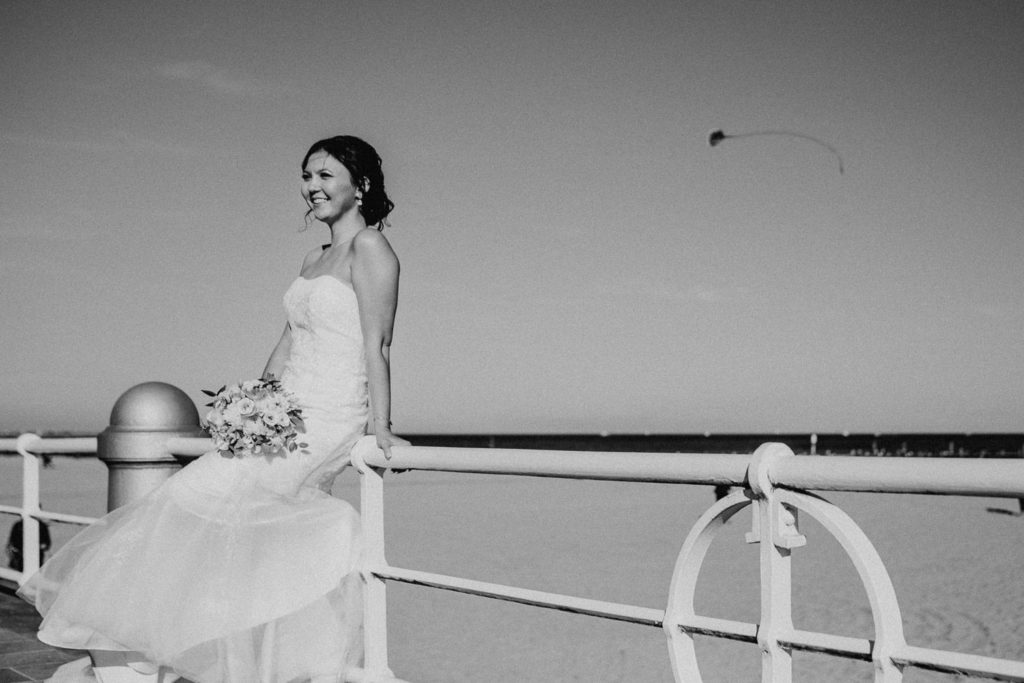Braut sitzt am Strand