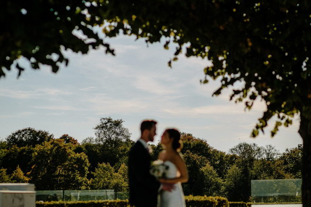 Brautpaar posiert unter Bäumen