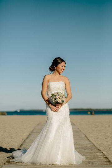 Bräutigam hat die Braut hochgehoben am Strand