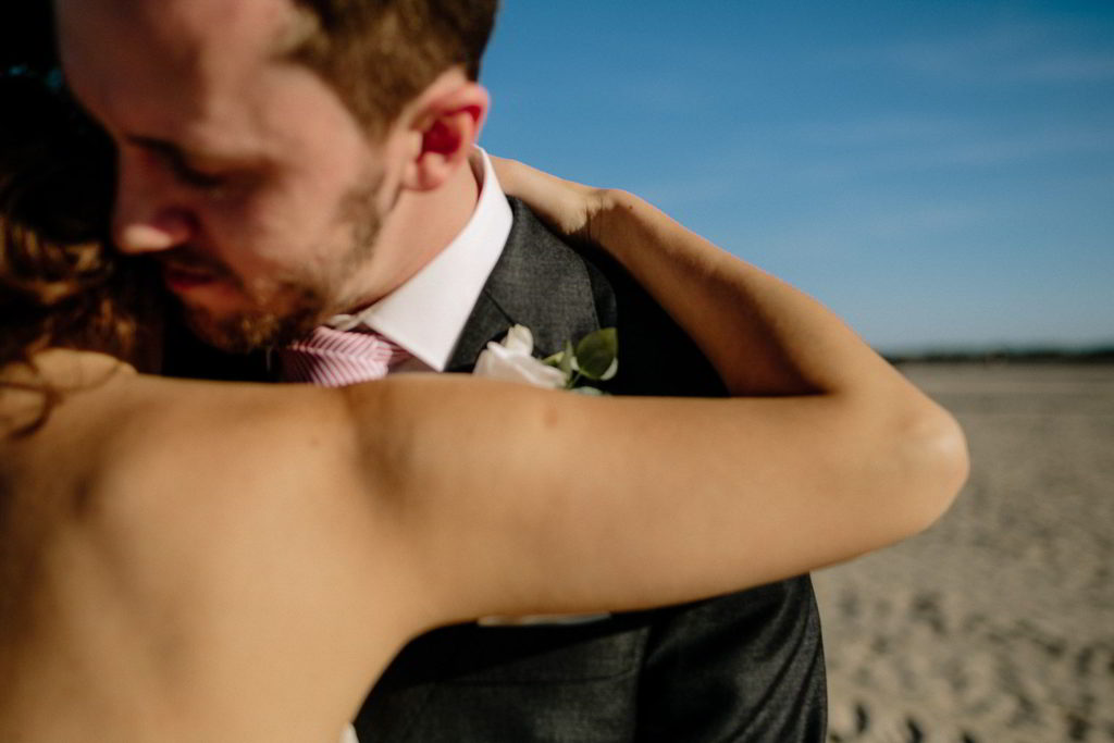 Brautpaar umarmen sich am Strand
