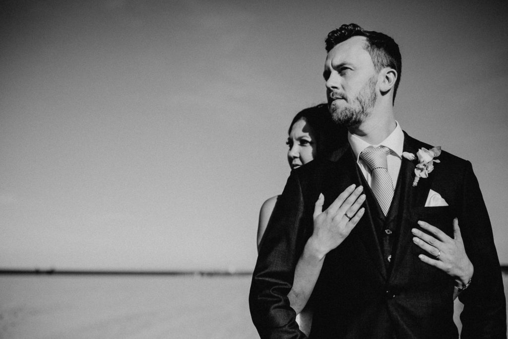 Brautpaar posiert am Strand schwarz weiß