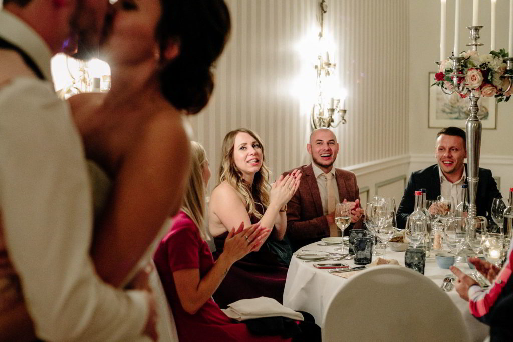 Brautpaar küsst sich Gäste applaudieren