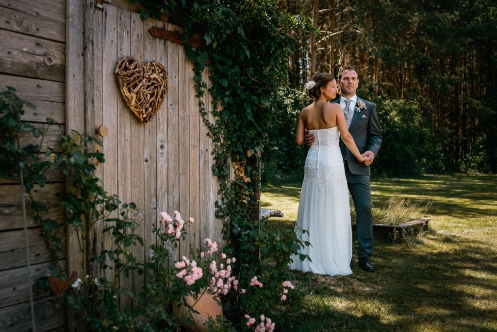 Brautpaar posen in Wittlohe vor einer Holztür